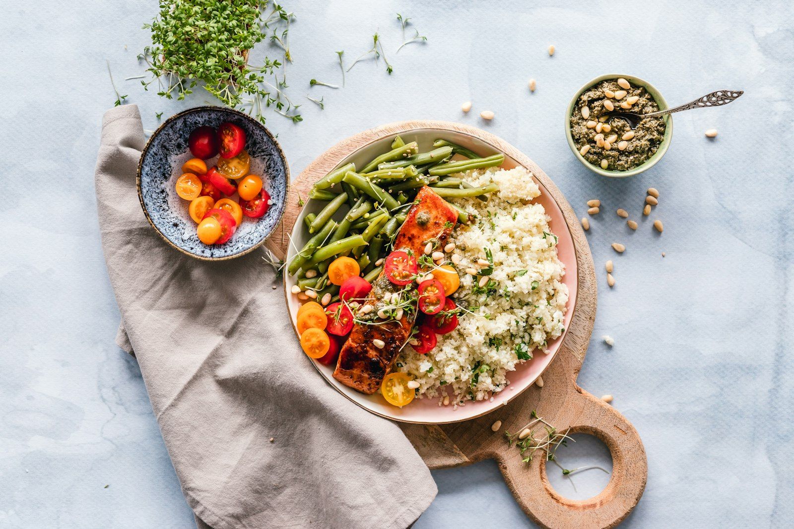 A wooden cutting board with bowls of fresh herbs, roasted vegetables, and grains — a typical Plate Notes meal in progress.