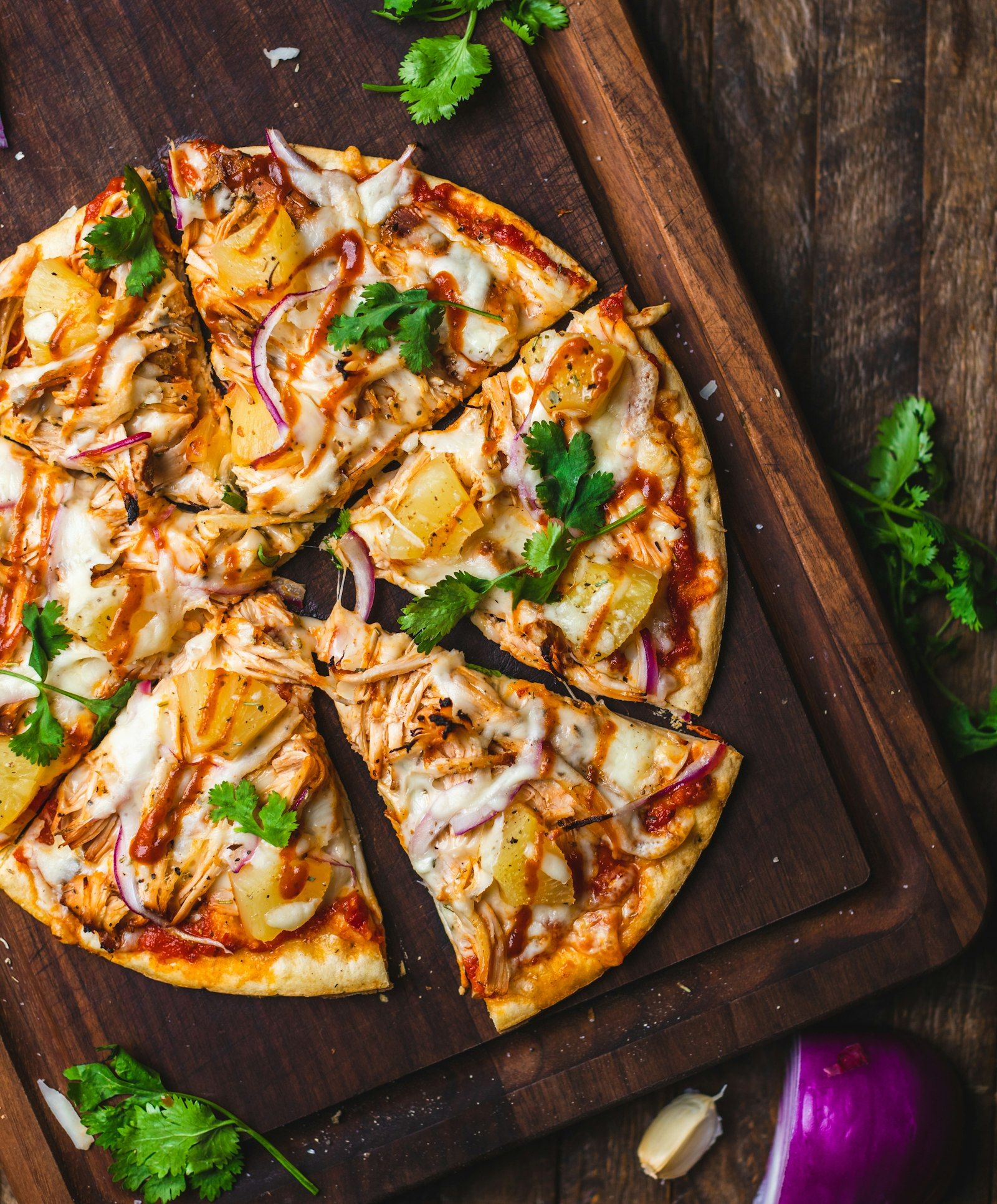 Three corn tortillas filled with seasoned black beans, cabbage slaw, and lime wedges on a wooden board.